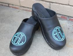 Black leather clogs with a teal monograem in ea circle font Black leather clogs with teal monogram NULL